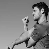Man in a gray shirt against a plain background